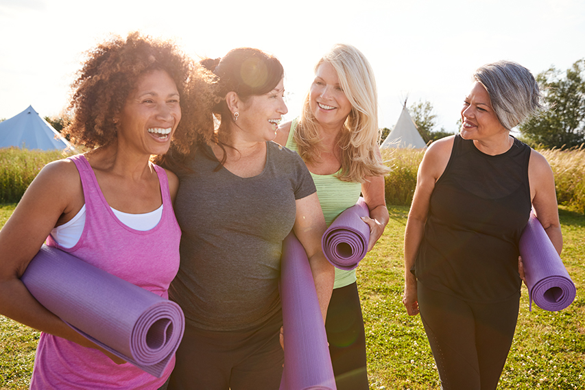 Group of women with yoga mats walking together